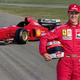 Michael Schumacher stands in front of the 1996 Ferrari F1 car.